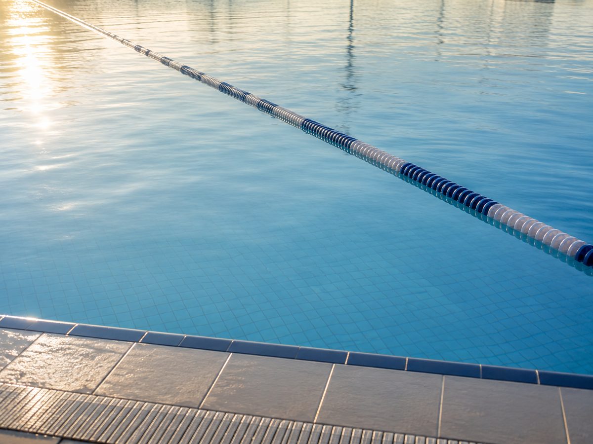 Arthritis: What It Is, Why Some People Get It, and How to Support Your Joints Naturally The calm blue surface of an outdoor swimming pool at sunrise, with a floating lane rope running diagonally across the water